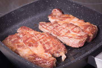 Two piece of steak cooking on grill pan