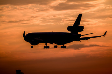 Obraz na płótnie Canvas Airplane landing at sunset