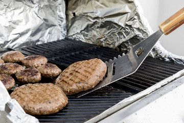 Juicy cutlets on the grill. Large juicy cutlet on the grill is turned over. Tool for grilling. Selective focus