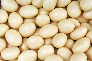 White chocolate bonbons drops candies balls texture pattern as background wallpaper.