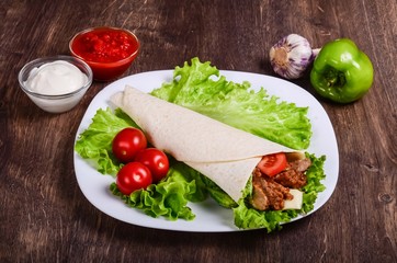 Burito with meat. Fried pork, beef, tomatoes