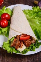 Burito with meat. Fried pork, beef, tomatoes