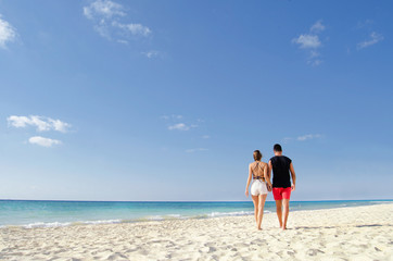 Fototapeta na wymiar Couple walking at the beach
