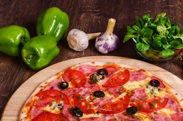 Thin pizza with ham and tomatoes