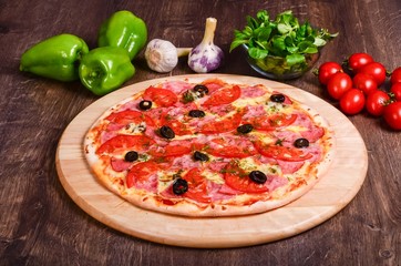 Thin pizza with ham and tomatoes