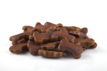 Pile of dog treats on a white surface. Dog cookies isolated on a white background.