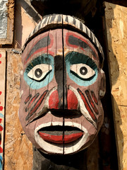 Authentic painted wooden totem pole in an African village. Original sculpture in wood. Wood tribal sculpture, colored portrait. 