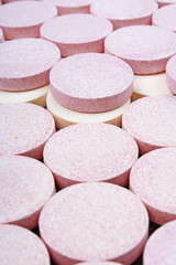 Stack of vitamin mineral supplement effervescent tablets pattern texture. Multivitamin supplement tablet. Soluble Vitamin. Fizzy tablet. Orange flavored effervescent tablets.