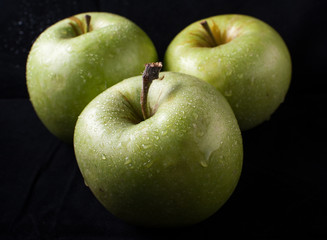 Green apple on black background