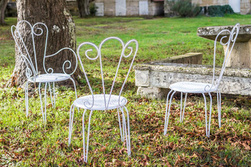 Decorative vintage metal white chairs furniture in a garden