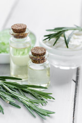 close up body care rosemary cosmetic products on white wooden desk background