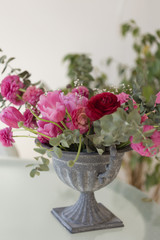Pink ranunculus flower and pink tulips arranged in iron vase