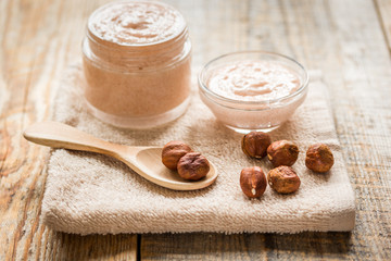 cosmetic for women with hazelnut scrub on desk background