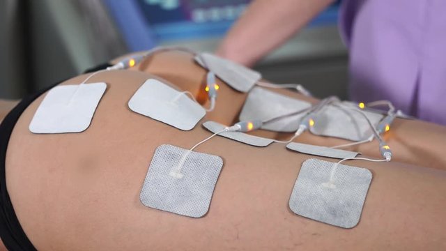 Close up lady at electro stimulation therapy. Electro bio stimulation of butt. Rejuvenation procedure. Concept of hardware cosmetology.