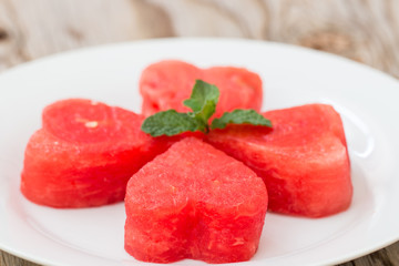 Watermelon on  white plate and wooden background.