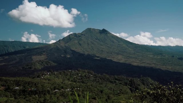 Mount Batur volcano view from Kintamani on sunny summer day with blue sky and small clouds in Bali, Indonesia. Shot with Sony a7s on tripod