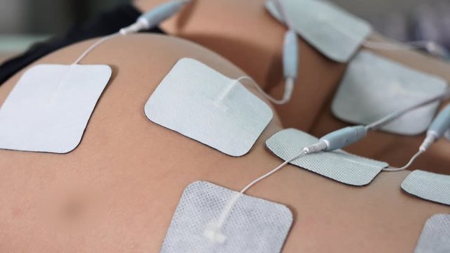 Close up of electro stimulation treatment in beauty salon. Regain beauty procedure of female butt. Hardware cosmetology.
