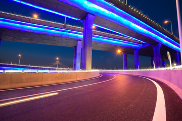 Empty road floor with city viaduct bridge of neon lights night