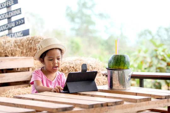 Asian Little Girl Is Playing Ipad Tablet In Vintage Color Tone