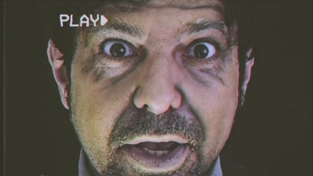 Fake VHS tape: an angry old man looking at the camera with a threatening face. He puts off his eyeglasses and gets really close.
