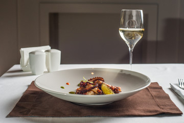 close up of cooked octopus on a white plate