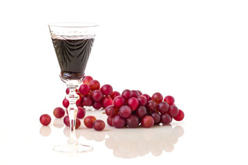 Glass of red wine and red grapes.