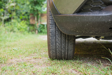 The Front tire of cars parked on grass.