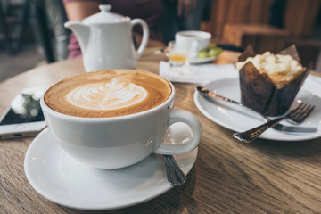 cup of coffee on old wooden desk. Simple workspace or coffee break in morning/ selective focus