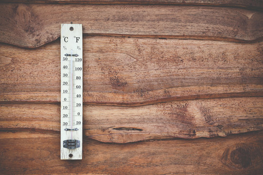 Wood thermometer calibrated in degrees celsius on the wooden wall, concept of world hot and weather.