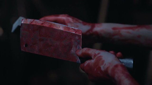 Bloody butcher sharpening chopping knife and preparing for murder, slow-mo