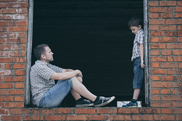 Portrait of sad little boy and father.