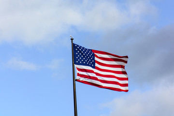 Obraz premium USA flag wave in the wind under blue sky
