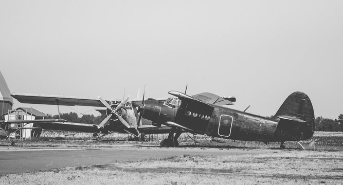 Стоянка старых самолётов. Винтажная чёрно-белая фотография. Старые винтовые самолёты на аэродроме
