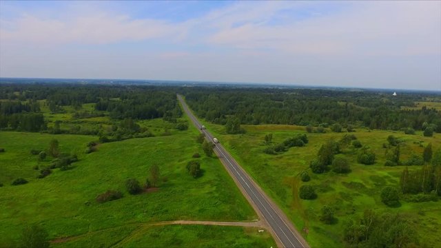 Drone flight over the highway among the green forests