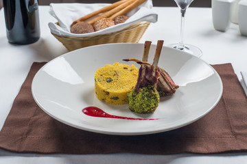 Rack of lamb grilled with porridge of millet on a white plate