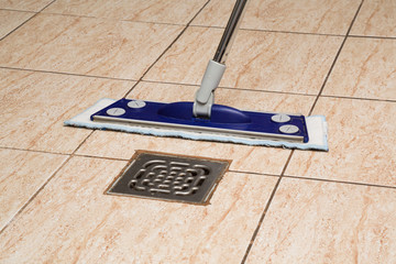 Tiles floor washing with mop in the kitchen. Regular clean up. Maid cleans house.