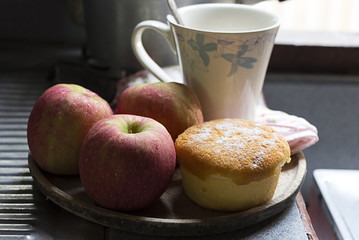 Red apple, bakery and cup of coffee on wooden tray.