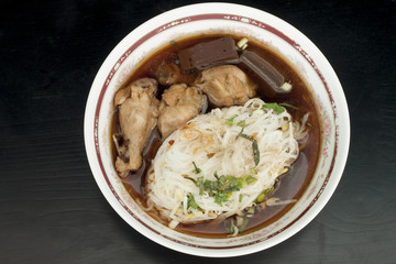 Chicken noodle soup food of Thailand on wood black color.