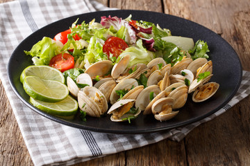 Clams with greens and fresh salad close-up on a plate. horizontal