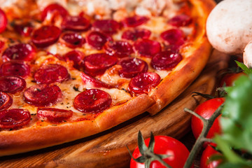 Italian cuisine. Delicious hot pizza sliced and served on wooden platter, close up view. Appetizing food background, menu concept