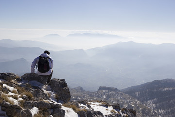 Hiker on the summit of a mountain with snow