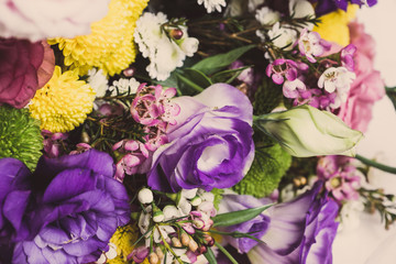 Bouquet with a lot of different flower on the wooden background. Shallow depth of field. Toned image.