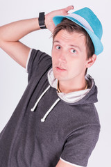 Charming handsome young man in formalwear Holds a blue hat white background