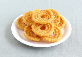Chakli, also known as murukku, which is a south Indian traditional, popular and vegetarian snack, on a plate. © Greentree
