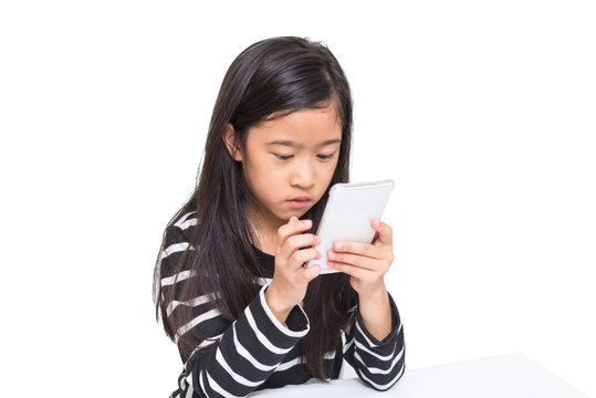 Cute asian girl kid playing smartphone to search video clip on the internet in her free time, isolated on white background (clipping path included)