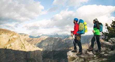 Photo sur Plexiglas Alpinisme Young mountaineers standing with backpack on top of a mountain and enjoying the view