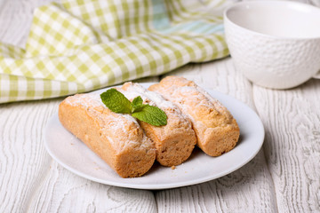 Eclairs with vanilla cream on a white plate