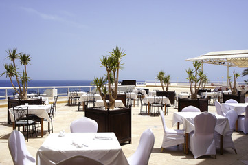 The tables in the outdoor restaurant by the sea. Original interior