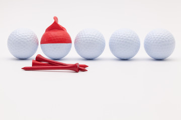White golf balls with funny cap on the white background.