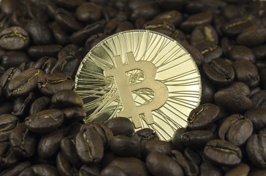 Coffee beans and bitcoin coins laying on white background